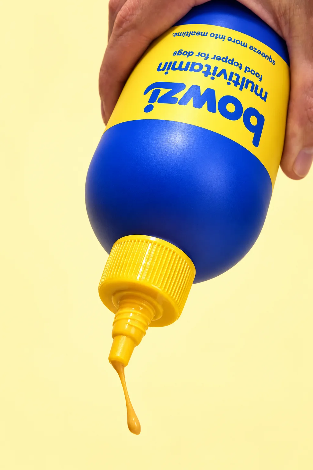 Close-up of a hand squeezing the Bowzi bottle